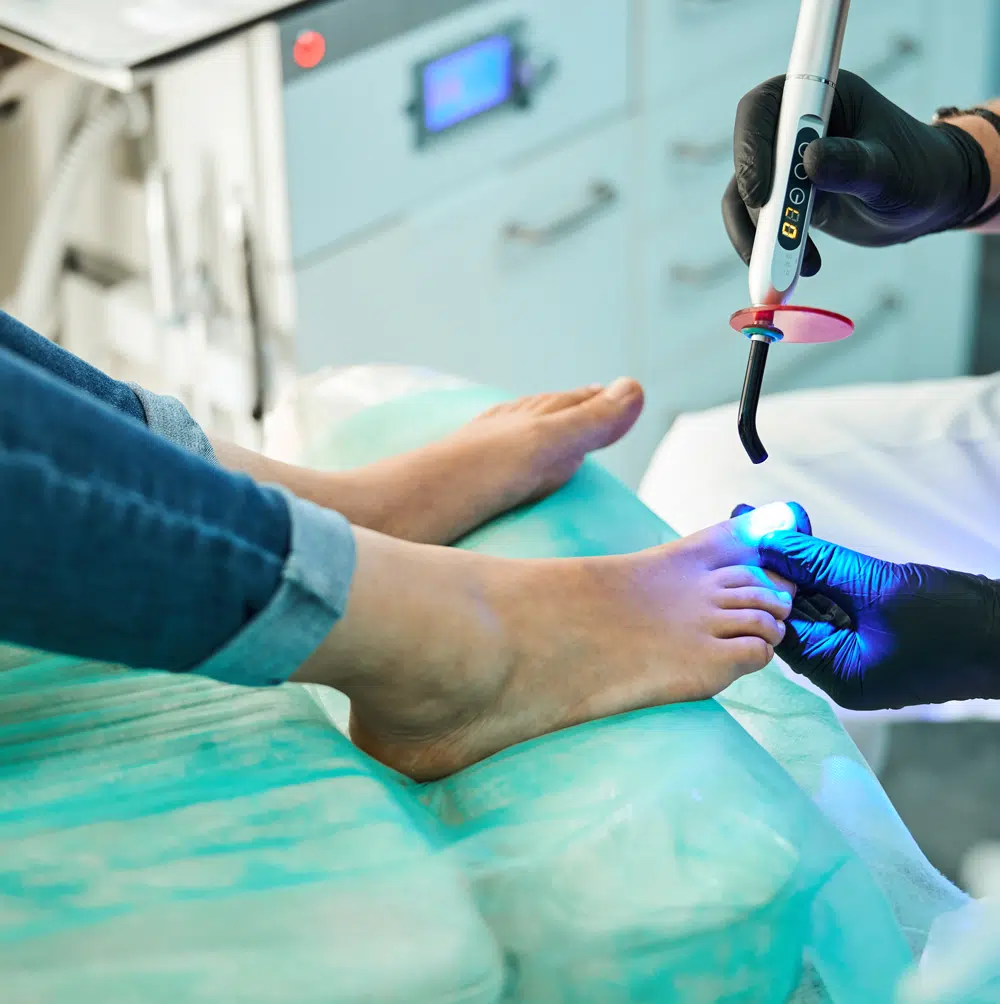 focused-photo-on-female-podiatrist-using-UV-lamp